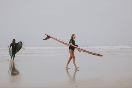 LQ_Blog_2_surfers_carrying_boards_at_beach.png